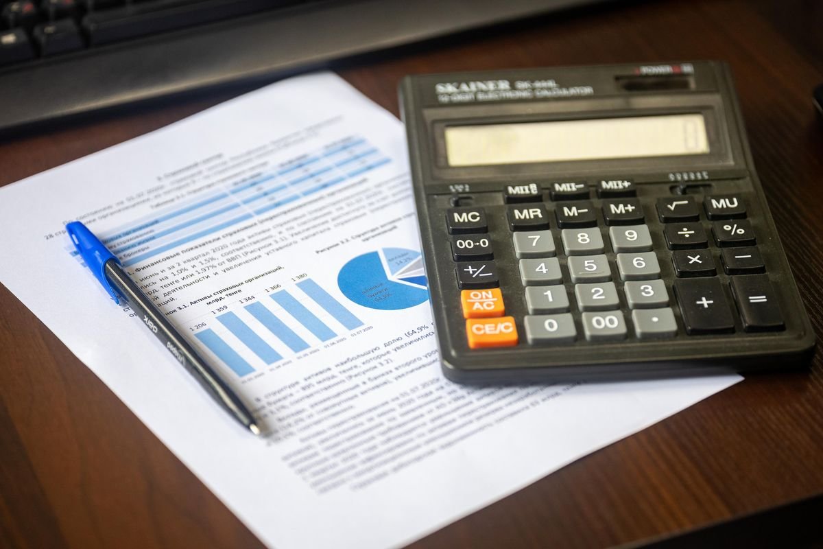 Calculadora e relatório financeiro sobre uma mesa