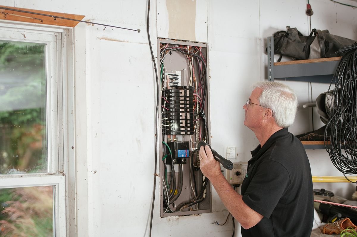 Eletricista inspecionando um quadro residencial
